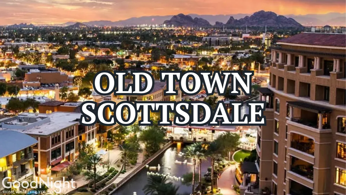 A panoramic view of Old Town Scottsdale is presented here, featuring illuminated buildings, the picturesque canal, and a backdrop of surrounding mountains. The atmosphere is inviting, capturing the allure of evening outings, dining, and cultural events.